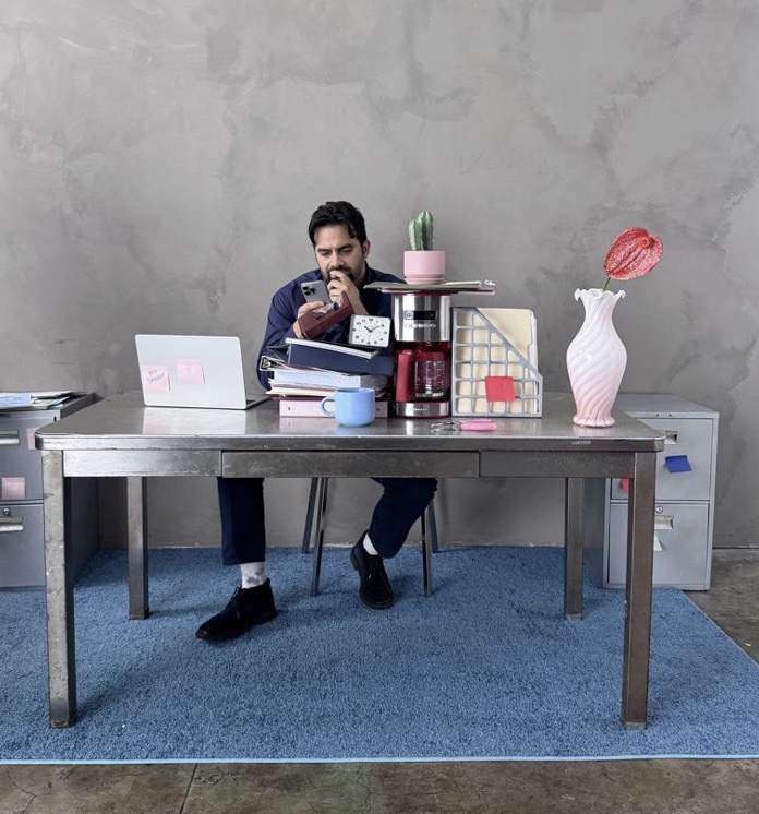 Designer at a desk stacked with product samples